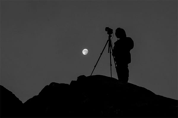 Photo guide Terry stood under a full moon during a photo expedition waiting for a Northern Light display
