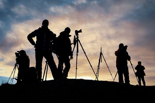 Silhouetted group of photographers capturing a sunset sky on a Northern Lights, Chasing the Light trip